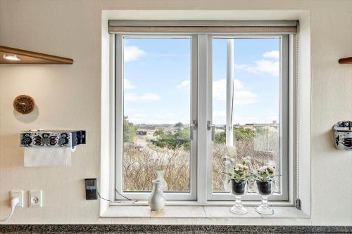 a window with two vases sitting on a window sill at 1177-Ringkobing-Anders-Juhls-Vej-10 in Søndervig