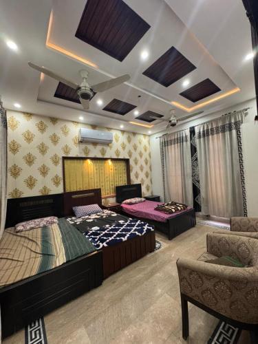a bedroom with two beds and a couch at 6-BedRoom house in Bahria in Lahore