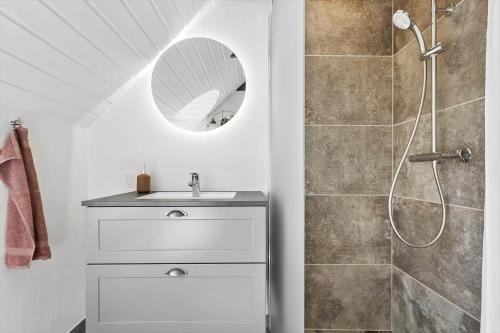 a bathroom with a sink and a shower with a mirror at 2227-Ringkobing-Fladsbjergvej-116 in Klegod