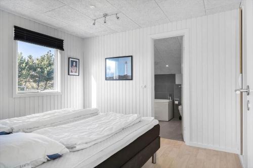 a bedroom with a large bed and a bathroom at 1102-Ringkobing-Gransangervej-14 in Nørby