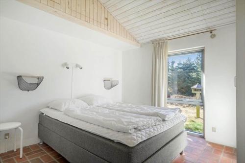 a bedroom with a bed and a large window at 2202-Ringkobing-Lyngvejen-73 in Klegod