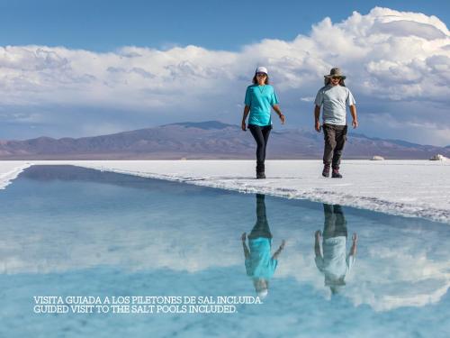 a man and a woman walking on a salt lake at Salinas Grandes Jujuy - Pristine Luxury Camp in Salinas Grandes