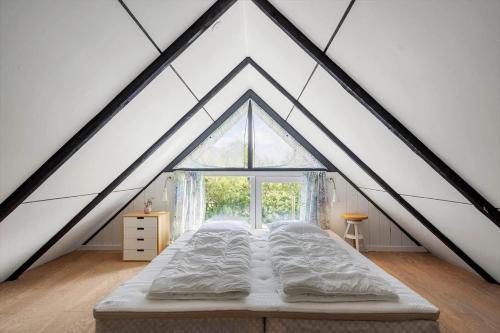 a bed in a room with a large window at 1196-Ringkobing-Sivsangervej-24 in Nørby