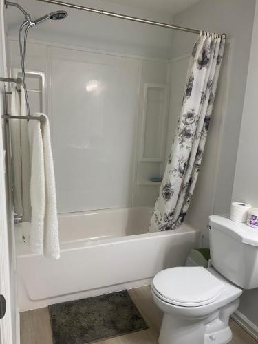 a bathroom with a white tub and a toilet at Blue Kuti B&B in Edmonton