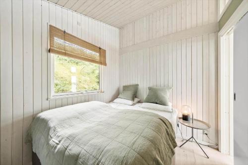 a white bedroom with a bed and a window at FY325-Munkebo-Kamsbjerghuse-1-b in Munkebo