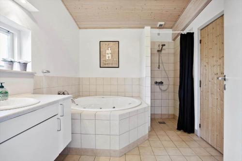 a white bathroom with a tub and a sink at FY293-Faaborg-Mosegarden-42 in Faaborg