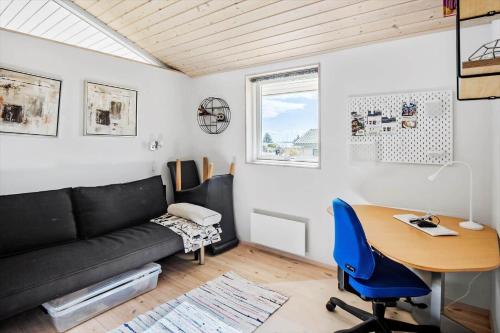 a living room with a couch and a desk and a table at FY289-Faaborg-Avernakovej-22 in Faaborg