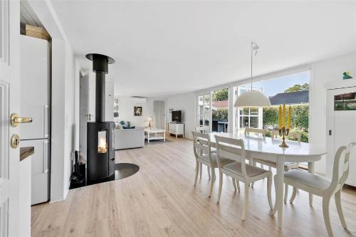 a white dining room with a table and a fireplace at FY318-Nyborg-Sommerbyen-23 in Nyborg