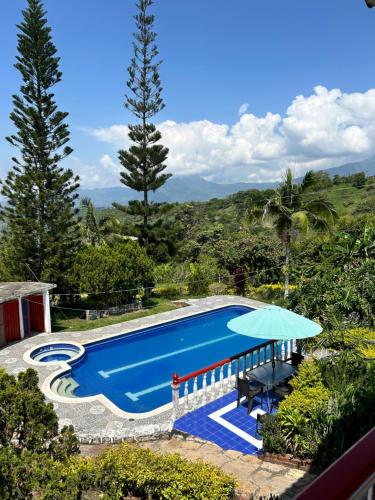 a swimming pool with a table and an umbrella at Finca Dinastia in Fusagasuga