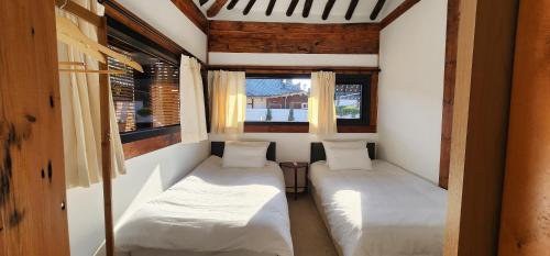 a small room with two beds and a window at Jahayeon Hanokstay in Jeonju