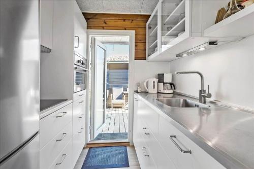 a kitchen with white cabinets and a door leading to a patio at FY349-Svendborg-Blaklokkevej-8 in Svendborg