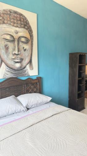 a painting of a buddha is above a bed at Cerro Escondido in Chiapa de Corzo