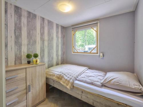 a small bedroom with a bed and a window at t Heische hofje in Zeeland