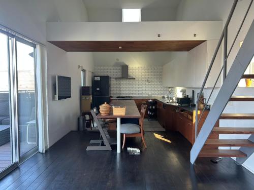 a kitchen and dining room with a table and stairs at Shimokitazawa Sanctuary , Spacious Stay for Families & Romantic Getaways in Tokyo