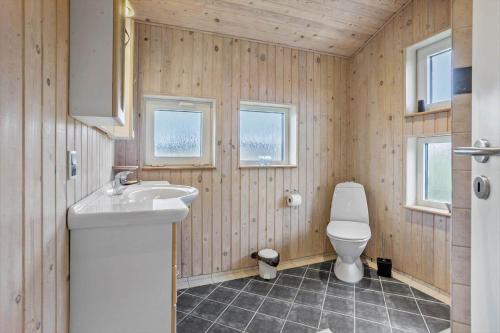 a bathroom with a toilet and a sink and two windows at FY287-Faaborg-Siovej-12 in Faaborg