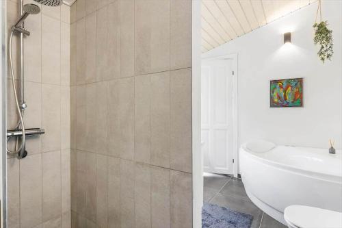 a bathroom with a shower and a white bath tub at FY100-Asperup-Bogevangsvej-4 in Asperup
