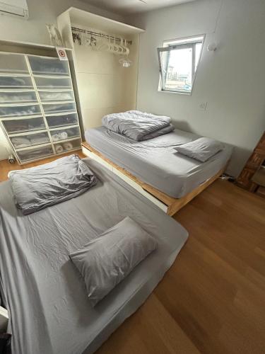 a bedroom with two beds and a window at Shimokitazawa Sanctuary , Spacious Stay for Families & Romantic Getaways in Tokyo