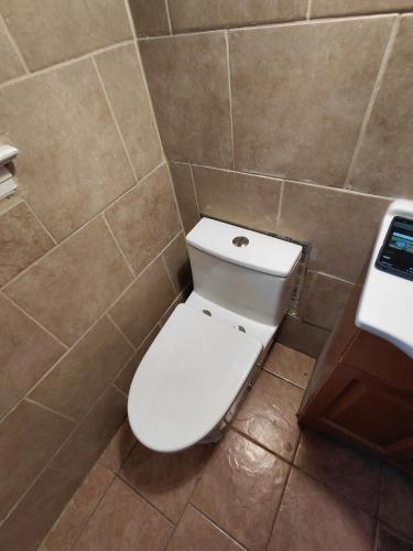 a bathroom with a white toilet in a tiled room at Quiet Harrisburg home in Harrisburg