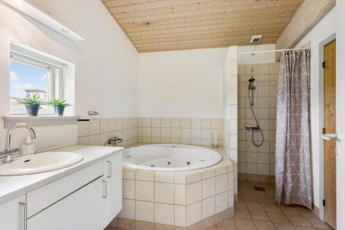 a bathroom with a tub and a shower and a sink at FY295-Faaborg-Mosegarden-39 in Faaborg