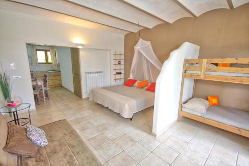 a bedroom with two bunk beds and a kitchen at La Dolce Vallata in Montefiore dellʼAso