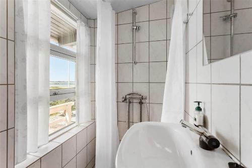 a white bathroom with a sink and a window at FY270-Faaborg-Lille-Stege-7 in Faaborg