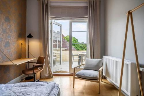 a bedroom with a bed and a chair and a window at FY399-Bogense-Ostergade-5-a in Bogense