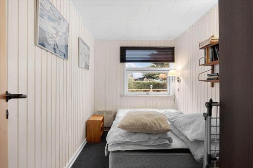 a small bedroom with a bed and a window at FY403-Asperup-Eskelundsvaenget-1 in Båring
