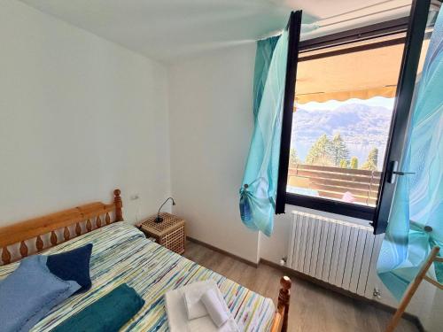 a bedroom with a bed and a large window at Prati Escape - Apartment with Pool and Lakeview in Lierna