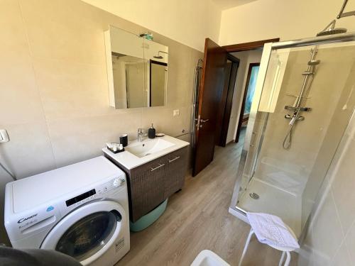 a bathroom with a washing machine and a washer at Prati Escape - Apartment with Pool and Lakeview in Lierna