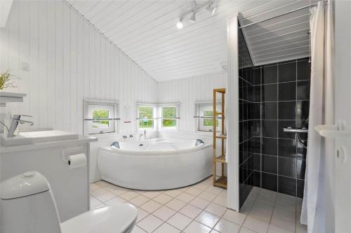 a bathroom with a tub and a toilet and a sink at C11221-Hemmet-Egernvej-2 in Hemmet