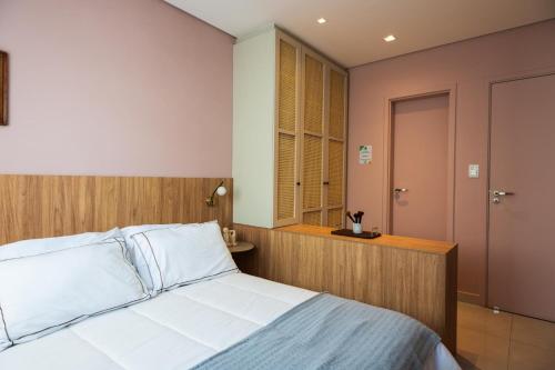 a bedroom with a white bed and a window at Chalé de Luxo com Piscina em Barra dos Coqueiros, Sergipe in Barra dos Coqueiros