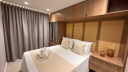 a bedroom with a large white bed with white towels on it at High Standard Two Bedroom Apartment Private Pool Frances Beach Garden 209 in Marechal Deodoro