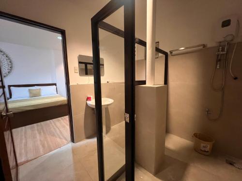 a bathroom with a shower with a toilet and a sink at OHANA Homestay in Coron