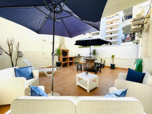 a living room with a large purple umbrella at Apartamento para férias 2 minutos da praia Costa da Caparica in Costa da Caparica