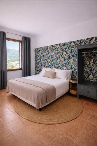 a bedroom with a large bed and a fireplace at Primavera House Port Sóller formerly Sol Port Sóller in Port de Soller