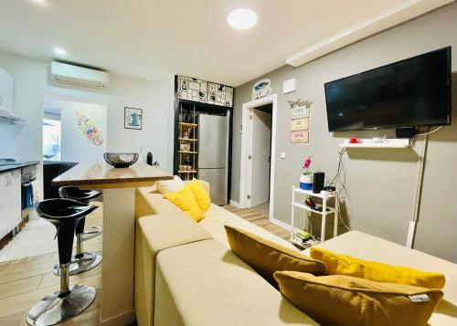 a living room with a couch and a flat screen tv at Apartamento para férias 2 minutos da praia Costa da Caparica in Costa da Caparica