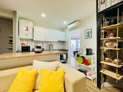 a living room with a couch and a kitchen at Apartamento para férias 2 minutos da praia Costa da Caparica in Costa da Caparica