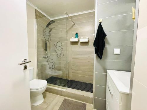 a bathroom with a shower with a toilet and a sink at Apartamento para férias 2 minutos da praia Costa da Caparica in Costa da Caparica