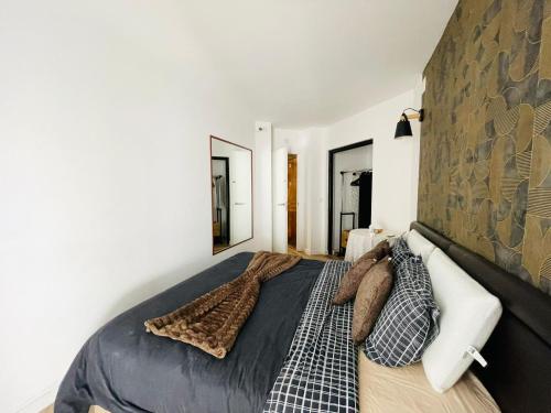 a bedroom with a large bed and two mirrors at Apartamento para férias 2 minutos da praia Costa da Caparica in Costa da Caparica