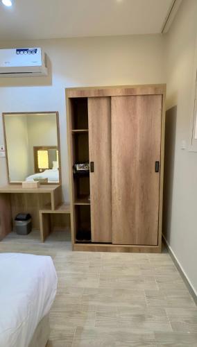 eine Holztür in einem Schlafzimmer mit einem Spiegel in der Unterkunft Alturya in Al-'Ula