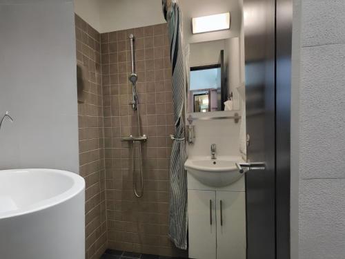 a bathroom with a sink and a shower at Dancenter Hotel Jomfru Ane Standard Double in Aalborg