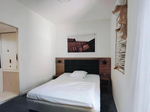 a bedroom with a white bed and a picture on the wall at Dancenter Hotel Jomfru Ane Standard Double in Aalborg