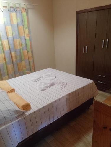 a bedroom with a bed with two towels on it at Hospedaria Café Terra&Sabor in Palmeiras