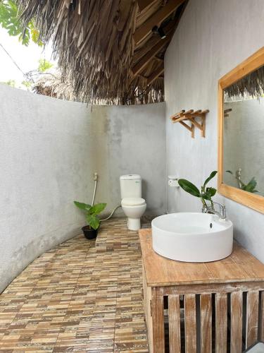a bathroom with a sink and a toilet at Sunset Rote Bungalows in Nembrala