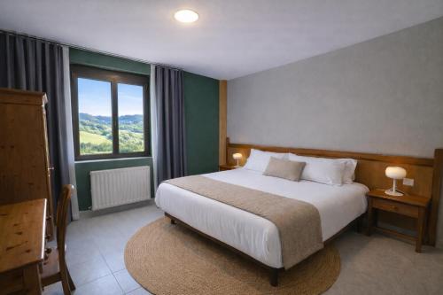 a bedroom with a bed and a large window at Coronel Somiedo by Unusual Hotels in El Puerto de Somiedo