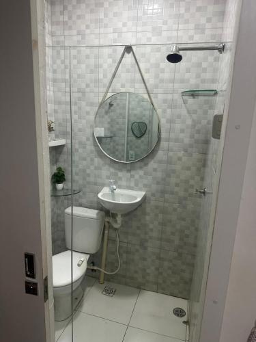 a bathroom with a toilet and a sink and a mirror at Casa Condomínio Reserva do Delta in Parnaíba