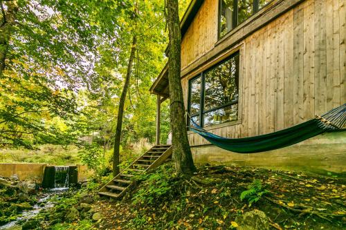 a hammock hanging from the side of a house at Le 14 Chalets Howard - Spa-Shower-Hammock-Bromont in Bromont