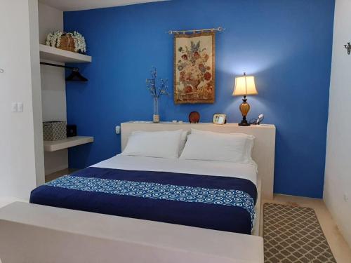 a blue bedroom with a bed with a blue wall at Hotel Casa de Campo Conkal Merida in Conkal