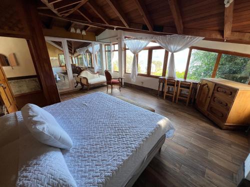 a bedroom with a bed in a room with windows at Mansión Del Arco in San Pedro La Laguna
