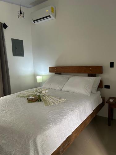 a bedroom with a white bed with a bow on it at Bungalows Chachagüita in Fortuna